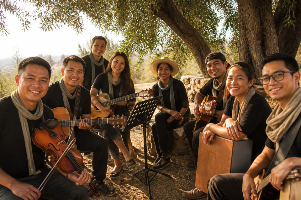 Davao Covenant Band with instruments under olive tree shade